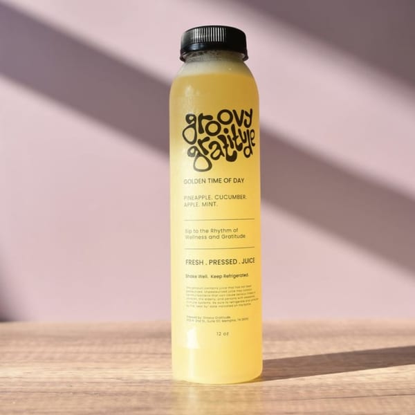 A bottle of Groovy Gratitude's Golden Time of Day juice, a blend of pineapple, cucumber, apple, and mint.